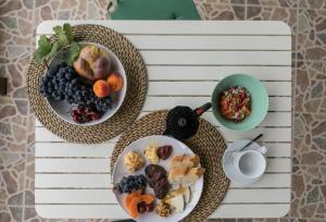 una mesa con dos platos de comida y un bol de fruta en Villa El Jable Lanzarote, en Teguise