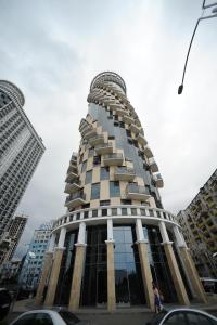 um edifício alto com muitas janelas em Orbi Sea Tower Apartment em Batumi