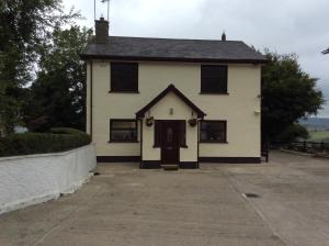 a white house with a door and a driveway at Bar View House in Newry