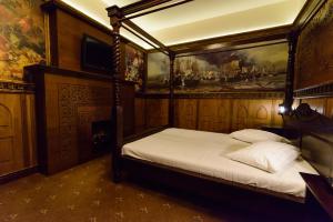 a bedroom with a canopy bed with a painting on the wall at LaCetate Boutique Hotel in Piteşti