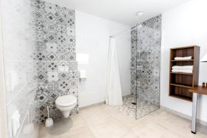 La salle de bains est pourvue d'une douche et de toilettes. dans l'établissement Hôtel Beau Site, au Lavandou
