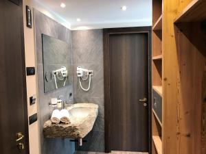 ein Badezimmer mit Waschbecken und Spiegel in der Unterkunft Hotel Le Cime in Val Masino + 71 Fotos