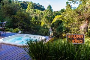 a jacuzzi tub on a deck with a sign at Pousada Lua de Pedra in Gonçalves