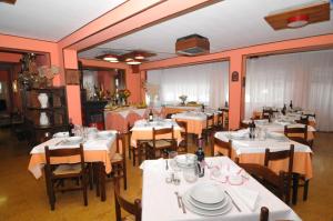 ein Esszimmer mit weißen Tischen und Stühlen in der Unterkunft Hotel Sport in Sestola