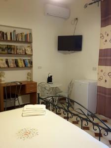 ヴィッラッジョ・モセにあるB&B il Giradiscoのテーブルと壁掛けテレビ付きの部屋