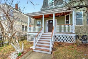 una casa con porche blanco y escaleras delante en 2 bedroom Boston condo in Jamaica Plain with parking, en Boston