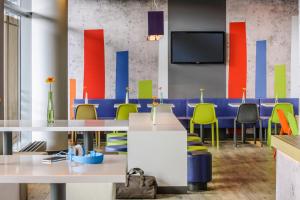 a conference room with tables and chairs and a tv at ibis budget Muenchen City Sued in Munich