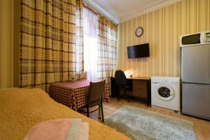 a bedroom with a bed and a desk with a washing machine at Apartment Nadezhda at Kabanbay Batyr 122 in Almaty