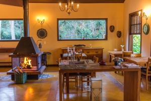 a living room with a fireplace and a table at Pousada Lua de Pedra in Gonçalves