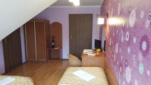 a room with a bed and a desk and a wall at Gościniec Kukle in Kukle