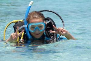 een jong meisje in het water met een snorkel bij The Beach Crab Resort in Pangani