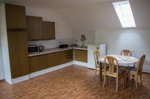 a kitchen with a table and chairs and a refrigerator at Ubytovani U Ruzenky in Velké Bílovice