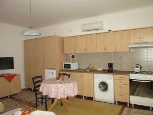 a kitchen with a table and a stove and a microwave at Garden City Apartment in Cluj-Napoca