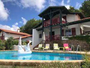 a house with a swimming pool with swans and chairs at Guest house Maison Iratzean in Ascain