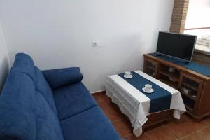 a living room with a blue couch and a table at Casa Conil Cruz in Conil de la Frontera