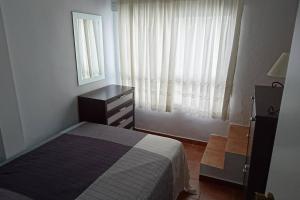 a bedroom with a bed and a dresser and a window at Casa Conil Cruz in Conil de la Frontera
