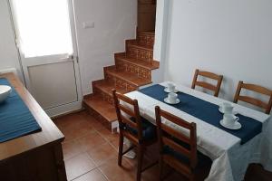 a dining room with a table and chairs and stairs at Casa Conil Cruz in Conil de la Frontera