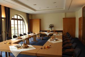 uma sala de jantar com mesas e cadeiras e uma janela em Hotel Lay-Haus em Limbach-Oberfrohna