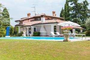 a villa with a swimming pool and a house at Le Margherite in Manerba del Garda