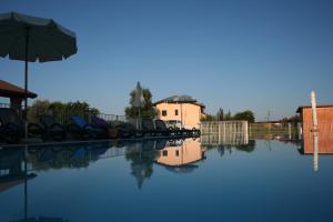 a pool of water with chairs and an umbrella at Agriturismo Ca' Del Gal in Valeggio sul Mincio