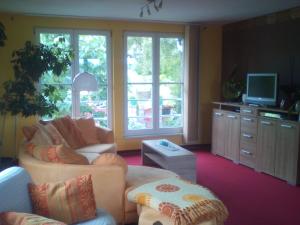 a living room with two couches and a tv at Ferienwohnung Naturnah in Dresden