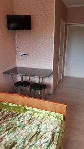 Habitación con mesa, sillas y cama en Glamour Hotel en Luhyny
