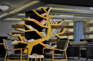 a book shelf filled with books next to chairs at Double Comfort Hotel in Ankara