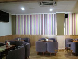 a waiting room with chairs and a wall with stripes at Hostal Banderas in Fuensanta de Martos