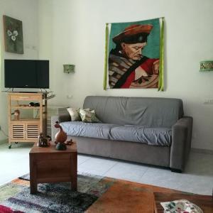a living room with a couch and a painting on the wall at Garden Bijou with Sea View in Vietri sul Mare