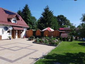a backyard with a fence and a garden with flowers at Cudowny Zakątek z Ogrodem i Basenem in Bukwica