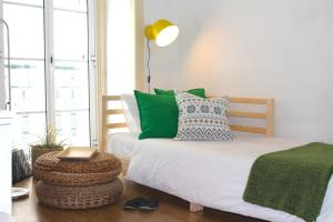 リスボンにあるWindow to Lisboa IIIのベッドルーム1室(緑と白の枕が備わるベッド1台付)
