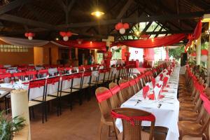 un comedor con mesas y sillas con asientos rojos en AR Sun Hotel, en Antsiranana