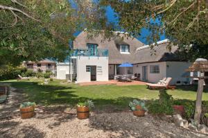 a house with a large yard with a patio at Cliff Cottage Hermanus in Hermanus