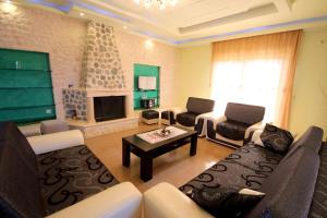 a living room with a couch and a fireplace at Mihal Suites in Sarandë