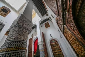 une vue sur le minaret d'une mosquée avec une colonne dans l'établissement Palais Nazha Fes - Luxury Lodging, à Fès