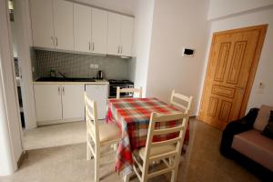 a kitchen with a table and chairs and a kitchen with a stove at Mihal Suites in Sarandë