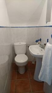 a bathroom with a toilet and a sink at Casa Conil Cruz in Conil de la Frontera +4 photos