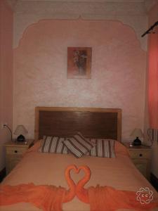 1 dormitorio con 1 cama con 2 flamencos pintados. en Riad Larache, en Larache