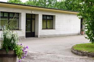 a white building with a driveway in front of it at Vinni Hostel in Vinni