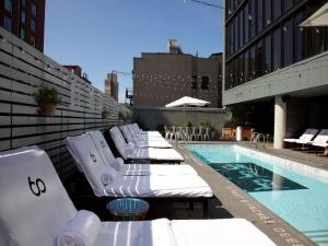 - une rangée de chaises longues à côté de la piscine dans l'établissement Sixty LES, à New York