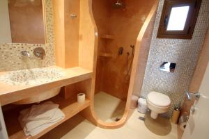 a bathroom with a sink and a toilet and a shower at Mihal Suites in Sarandë