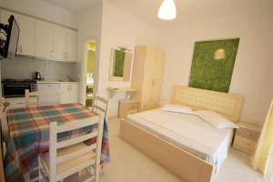 a small bedroom with a bed and a kitchen at Mihal Suites in Sarandë