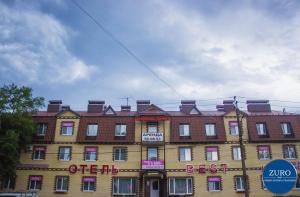 un grand bâtiment en briques avec un panneau. dans l'établissement Hotel Best-Zuro, à Ulyanovsk