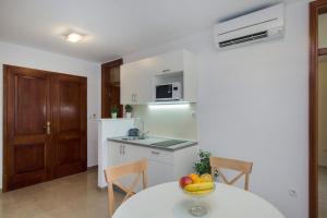 a kitchen with a table with a bowl of fruit on it at Apartman Ana in Skradin