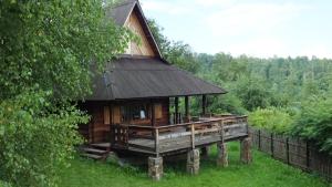 a large wooden cabin with a black roof at Domki nad Soliną in Olchowiec