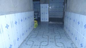 a bathroom with blue and white tiled floors and toilets at Rwenzori Trekking Homestay in Nyakalengija