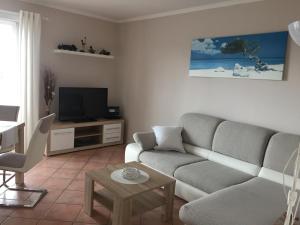 a living room with a couch and a television at Strandvilla Kalifornien direkt am Meer in Kalifornien