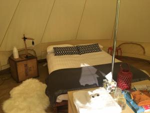 a room with a bed in a tent with a table at Twamley Farm in Buckland