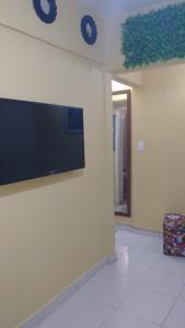 a wall with a flat screen tv on a wall at Apartamento Praia Grande in Praia Grande