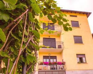 a yellow building with balconies and flowers on it at Balcon des Alpes in Teglio